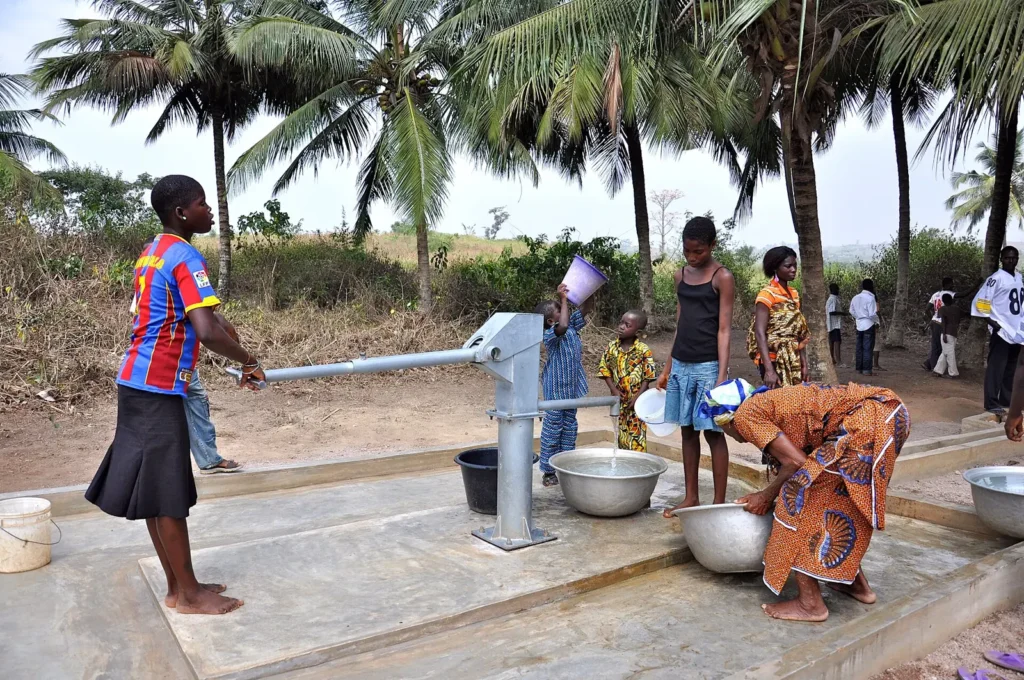 Habitants puisant de l'eau à une pompe manuelle